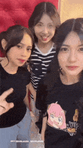 three girls are posing for a picture and one of them is wearing a shirt that says yuj