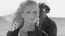 a black and white photo of a man kissing a woman