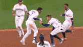 a group of baseball players wearing mariners jerseys are on the field