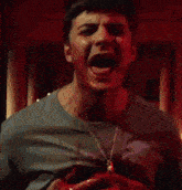 a man with his mouth open is holding a bloody object