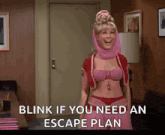 a woman in a pink outfit is standing in a room with the words " blink if you need an escape plan " on the screen