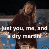 a woman in a red coat is pouring a martini into two martini glasses