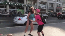 a man in a bathing suit is holding hands with a man in a pink hat in front of a store called forever 21