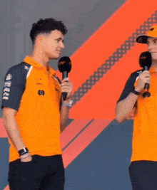 two men standing next to each other with microphones in their hands