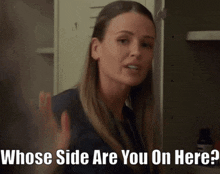 a woman is standing in front of a locker and says whose side are you on here