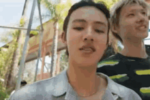 a man and a woman are standing next to each other in a park .