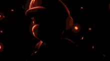 a person wearing headphones in a dark room with a red light behind them