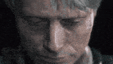 a close up of a man 's face with a tear running down his cheek