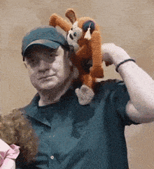 a man holds a stuffed animal on his head