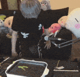 a man is sitting on a couch with stuffed animals and a microphone