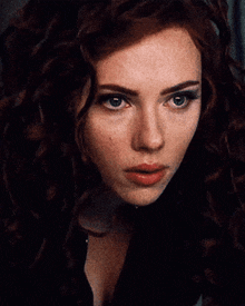 a close up of a woman 's face with a dark background