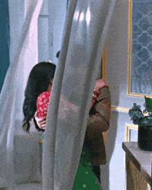 a man and a woman are hugging behind a curtain