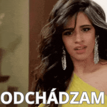 a woman in a yellow dress stands in front of a sign that says odchadom