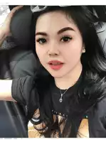 a woman sitting in a car wearing a black shirt that says t.i.r.e.