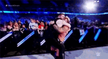 two wrestlers are hugging each other in a wrestling ring .