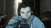 a man wearing headphones is sitting in front of a microphone and looking at the camera