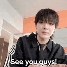 a young man wearing a black shirt and tie says see you guys