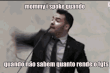 a man in a suit and tie is speaking into a microphone with the words mommy i spoke quando