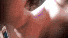 a close up of a person 's face with a purple and pink glow
