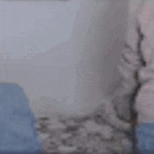 a woman is sitting on a bed holding a tissue box .