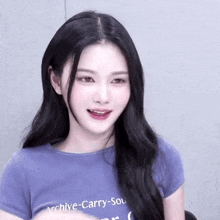 a young woman with long black hair is wearing a purple t-shirt with the word archive on it .