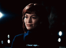 a woman in a dark room is saying i hear ego