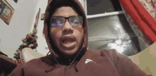 a man wearing glasses and a hoodie with the word nike on it