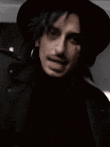 a man wearing a black hat and a black jacket