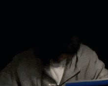 a man wearing glasses and a grey hoodie with the word almighty on the bottom