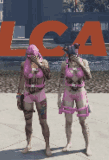 a couple of people standing in front of a large orange lca sign