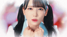 a close up of a girl with pigtails and a blue shirt
