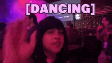a woman is dancing in front of a large screen that says dancing