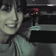 a woman is smiling while sitting in front of a computer screen