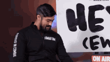 a man wearing a jacket that says " forged in combat "