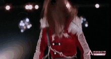 a woman in a red and white outfit is standing in front of a sign that says a