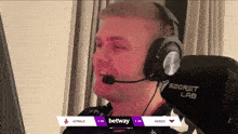 a man wearing headphones and a microphone is sitting in front of a computer screen that says astralis