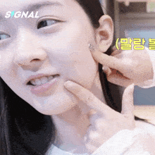 a close up of a woman 's face with the word signal in the upper right corner
