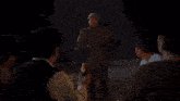 a group of people are sitting around a campfire at night
