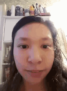 a woman is making a funny face in front of a shelf full of beauty products including crest