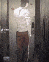 a man in a white shirt and red pants stands in front of a door with a tiktok watermark