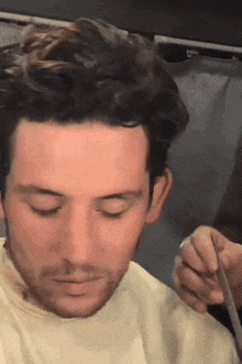 a man is getting his hair cut by a hairdresser