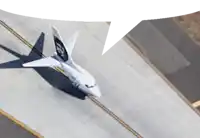 an aerial view of a plane on a runway with a speech bubble