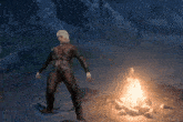 a man is standing in front of a campfire