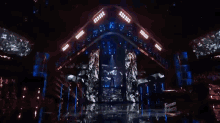 a woman singing into a microphone on a stage with a screen behind her that says teen talent