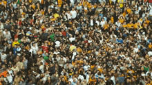 a large crowd of people are gathered in a stadium and one of them is wearing a yellow jersey with the number 8