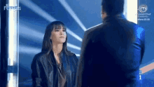 a man and a woman are standing next to each other and looking at each other on a stage .