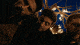a group of men standing in front of a tree with lights