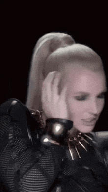 a woman with a ponytail covering her ears