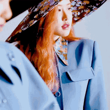 a woman with red hair is wearing a blue jacket and a hat