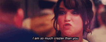 a woman is making a funny face and saying i am so much crazier than you